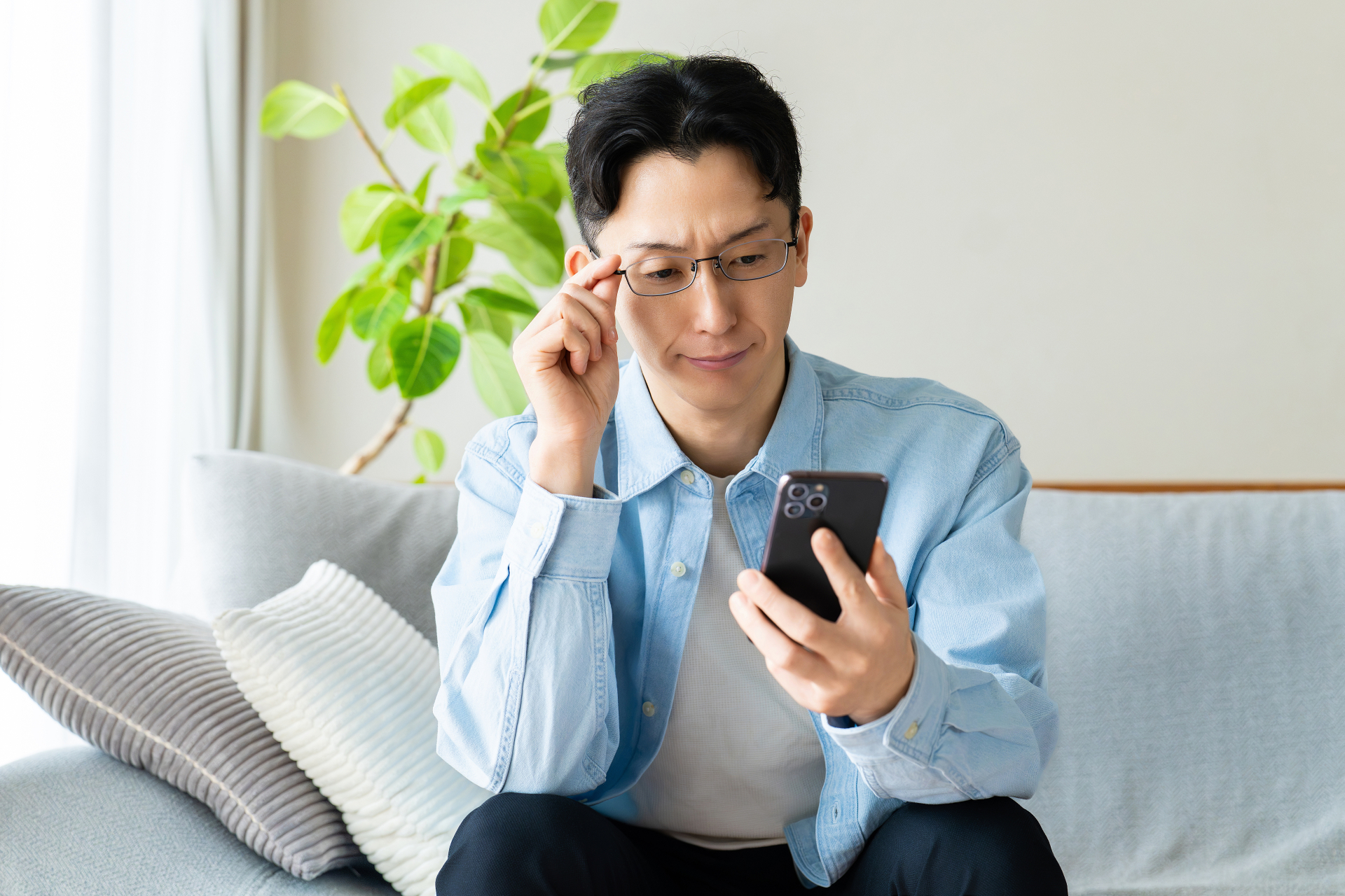 眼鏡をかけた男性がスマホを見ている画像