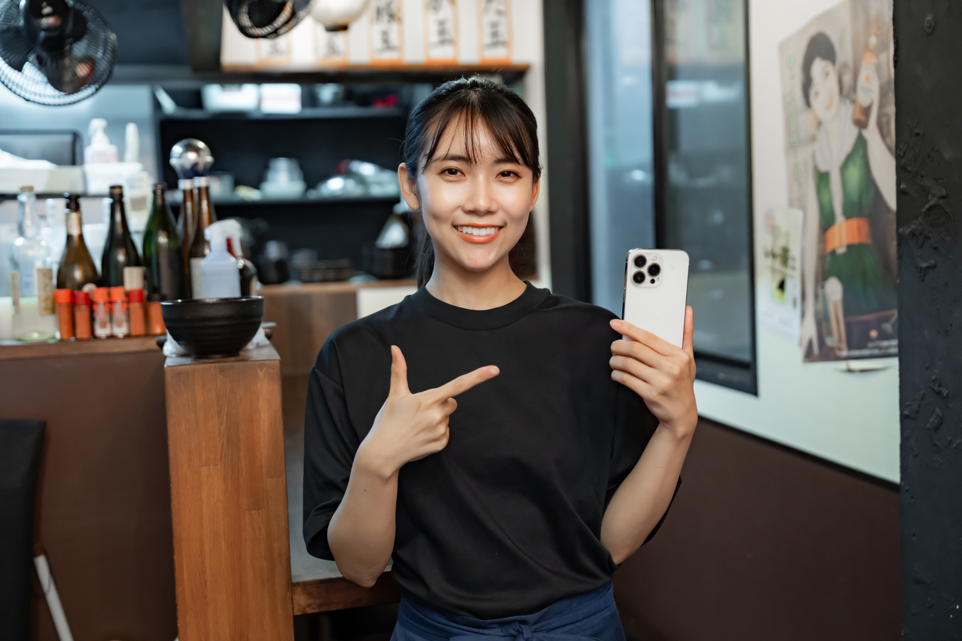 スマホを持つ飲食店で働く女性